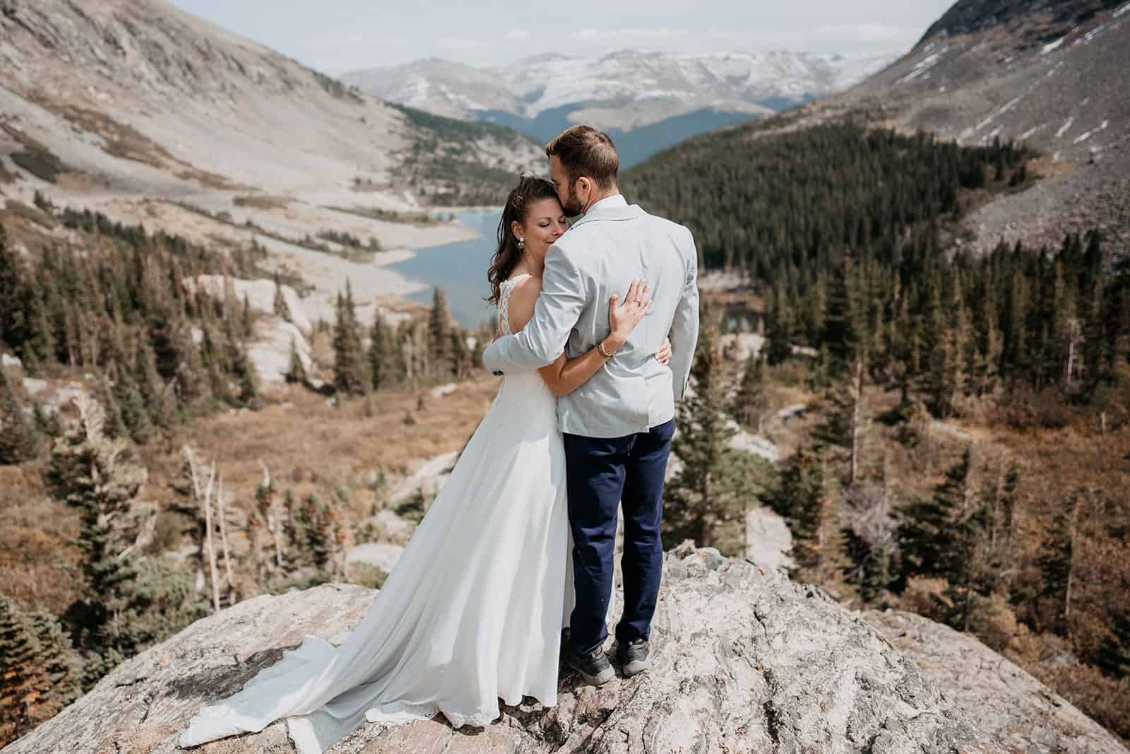 Bride and groom hugging on the top of a mountain after their Colorado elopement